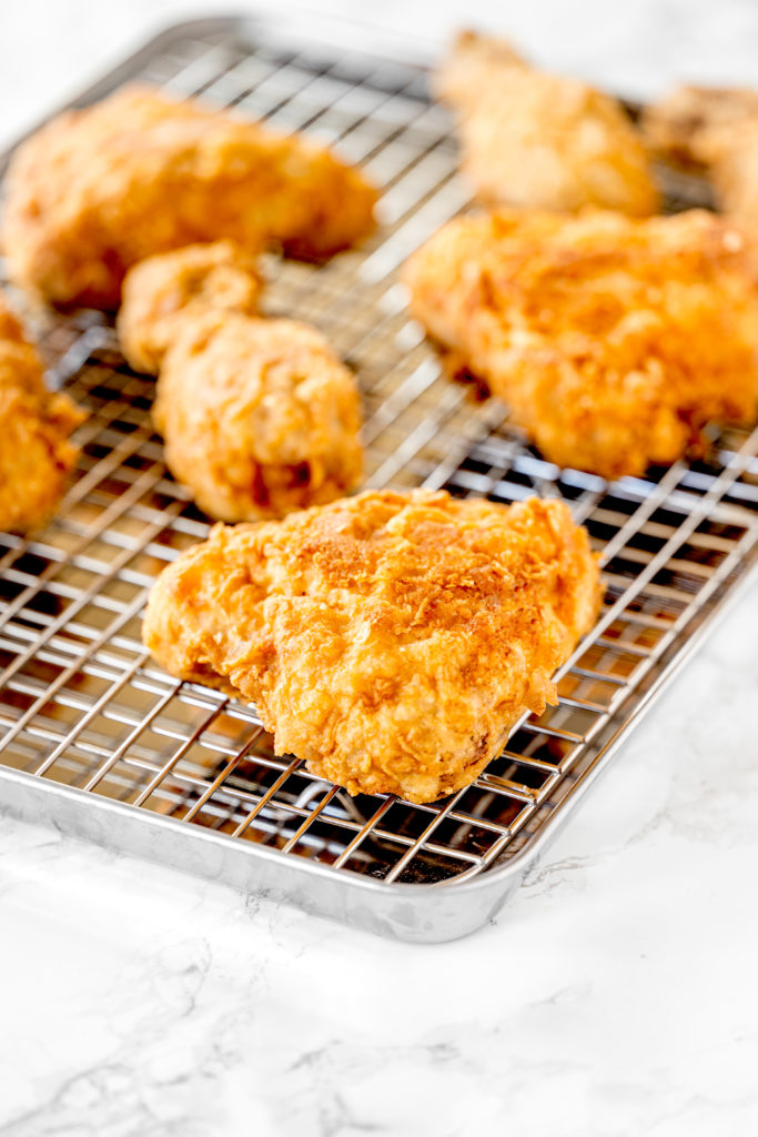 Fried chicken made without buttermilk sitting on a cooling rack 
