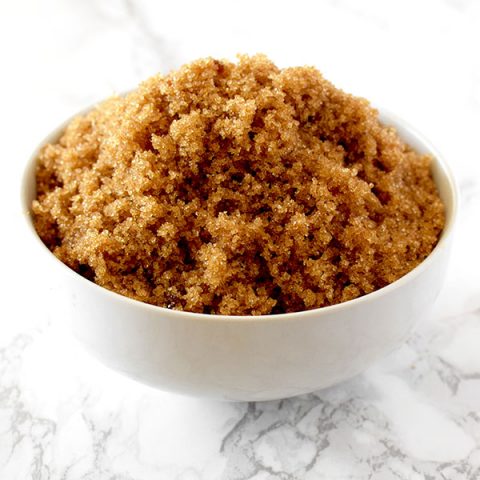 light brown sugar in a white bowl on a white marble counter