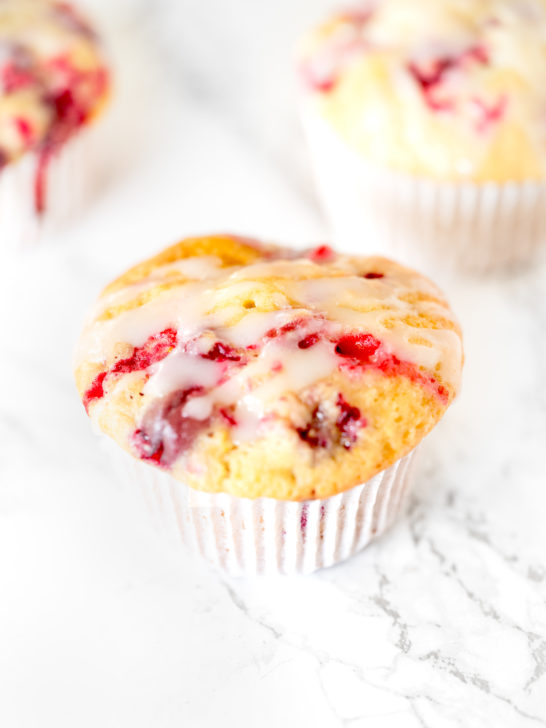 Dairy free cranberry orange muffins on a white marble counter