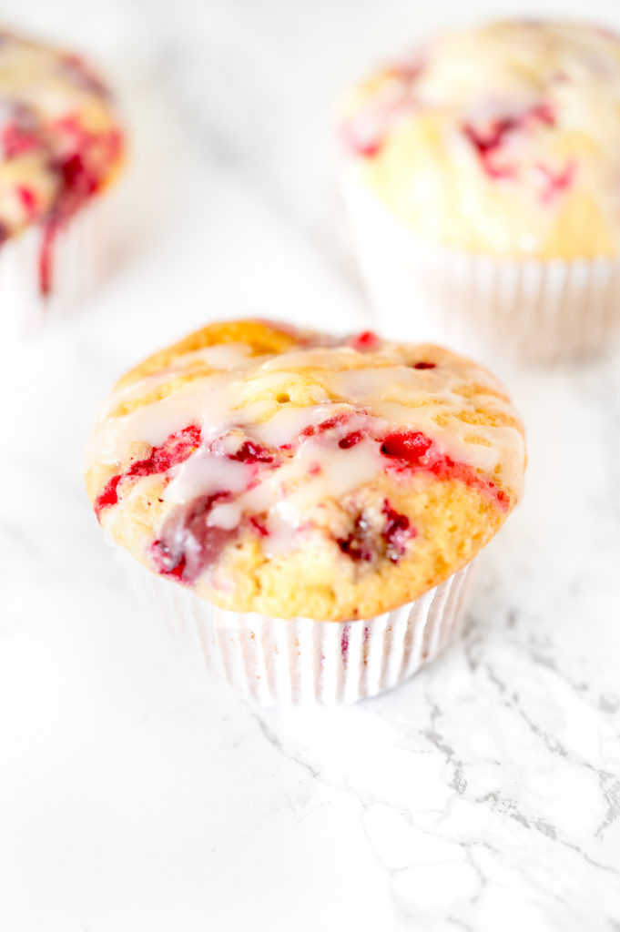 Dairy free cranberry orange muffins on a white marble counter