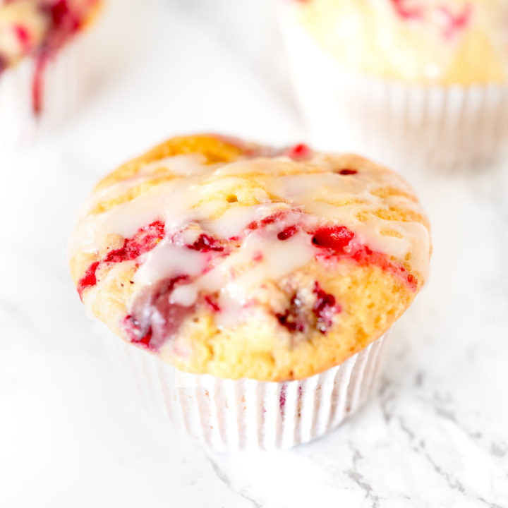 Dairy free cranberry orange muffins on a white marble counter