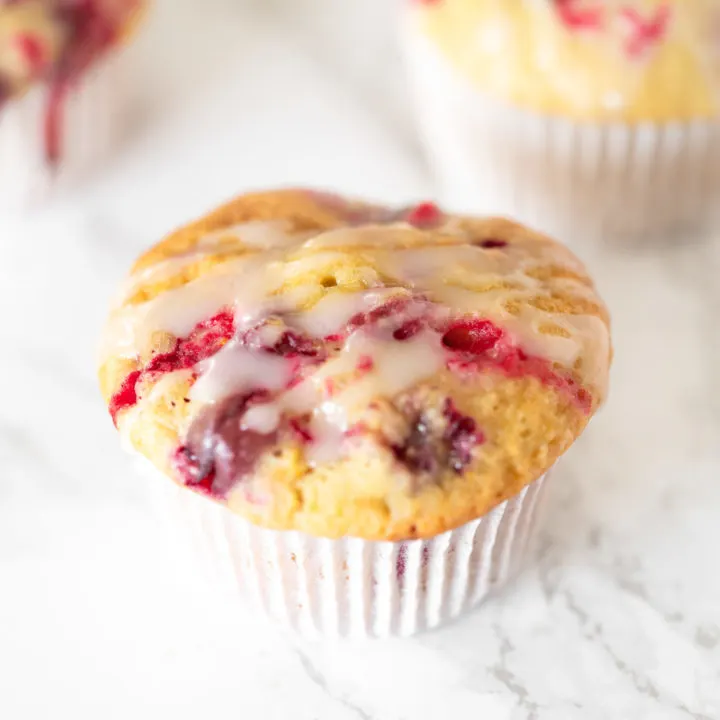 Dairy free cranberry orange muffins on a white marble counter