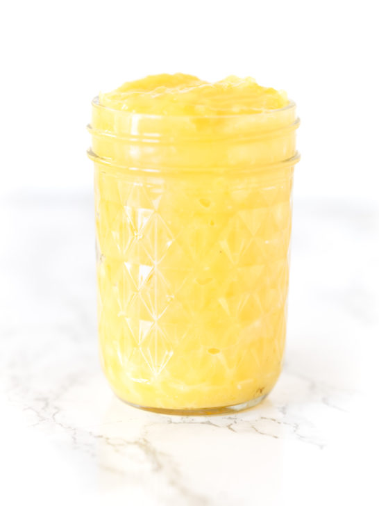 lemon curd in a jar on a white marble counter