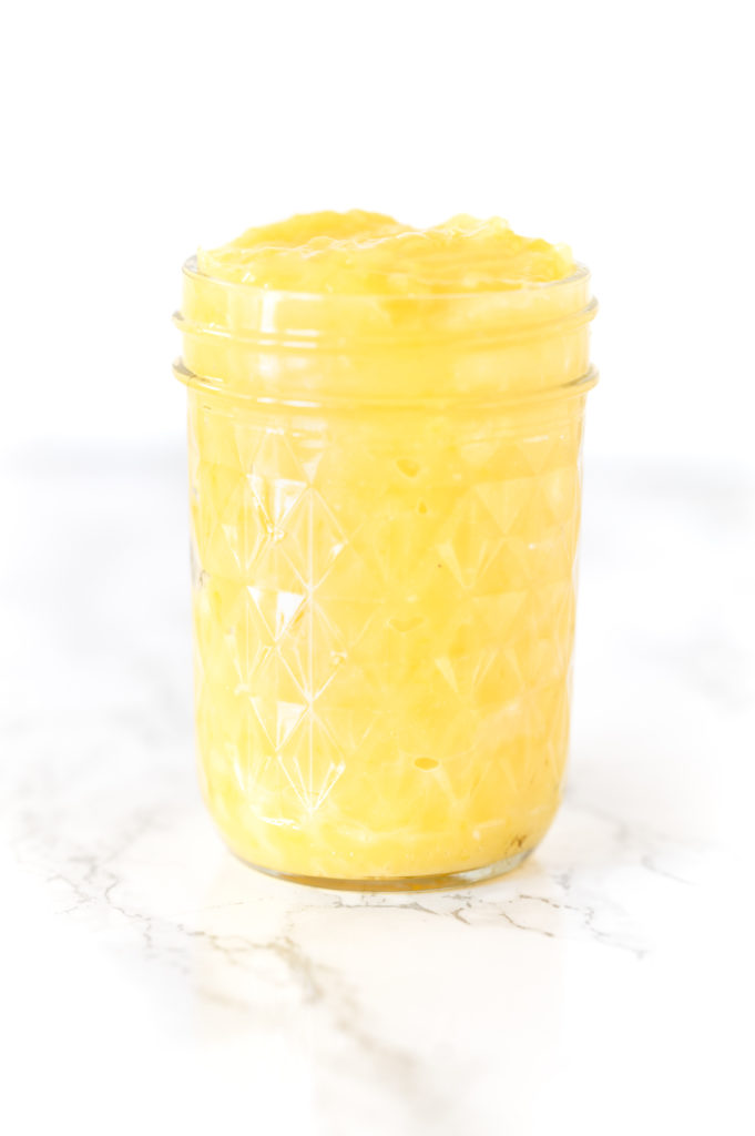 Dairy free lemon curd in a jar on a white marble counter