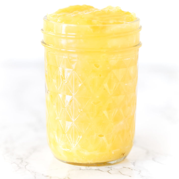 lemon curd in a jar on a white marble counter
