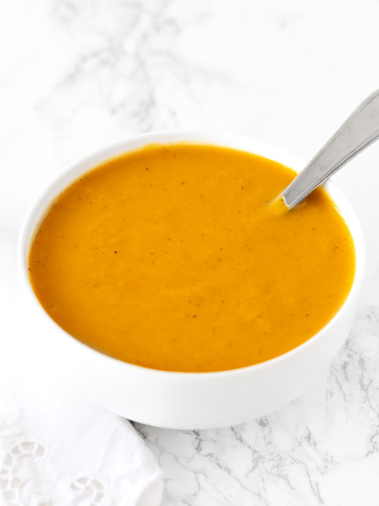 dairy free butternut squash soup in a white bowl on a white marble counter