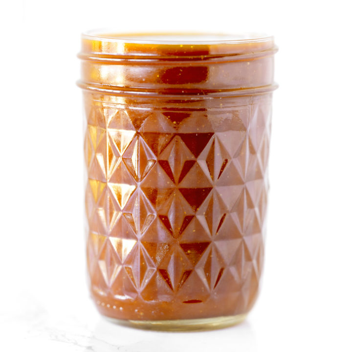 dairy free caramel in a glass jar on a white marble counter