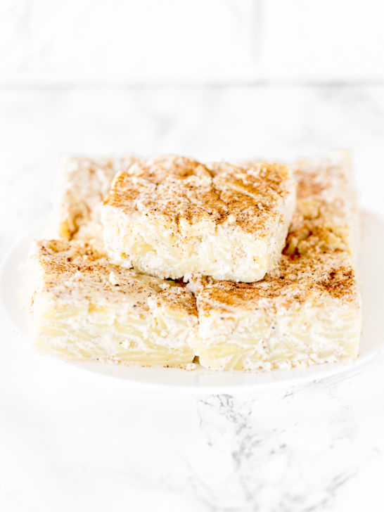 Noodle kugel on a white plate on a white marble counter