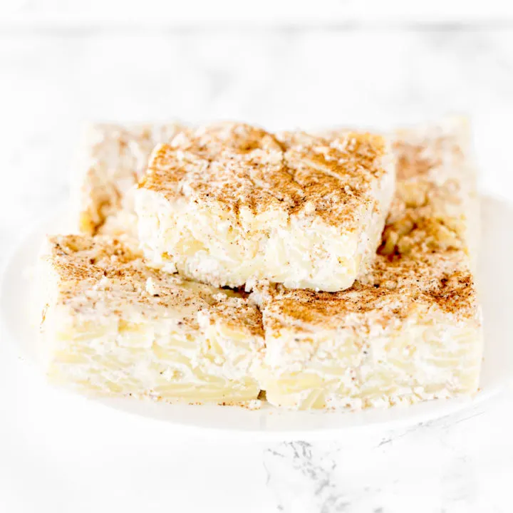 Noodle kugel on a white plate on a white marble counter