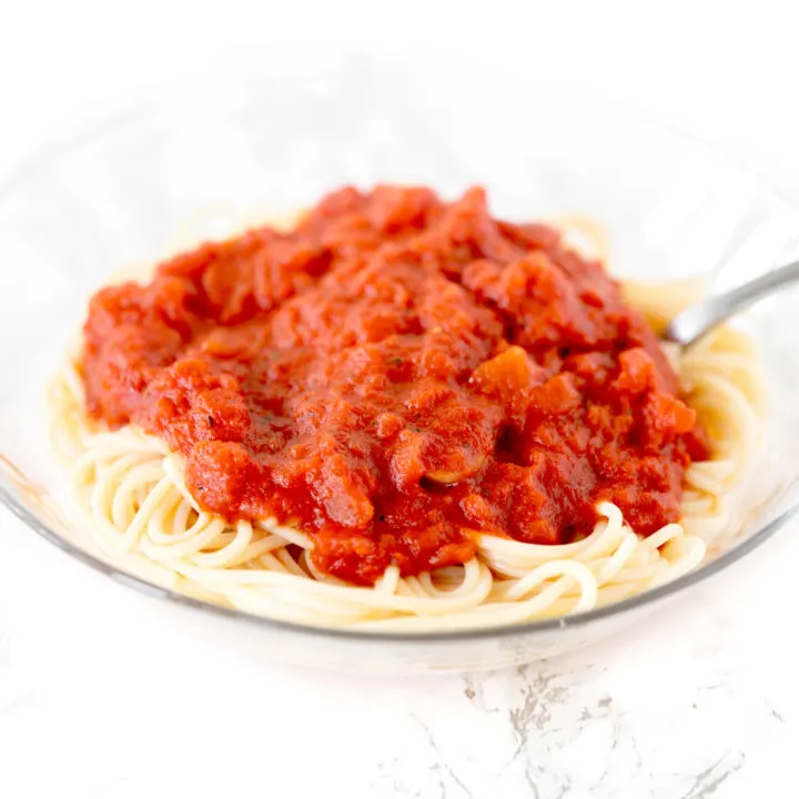 dairy free pasta sauce on a bowl of spaghetti on a white marble counter