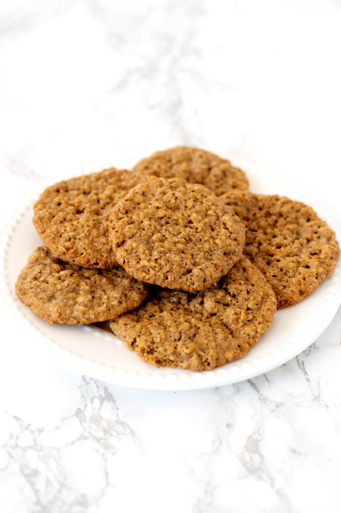 dairy free oatmeal cookies on a white plate on a white marble counter