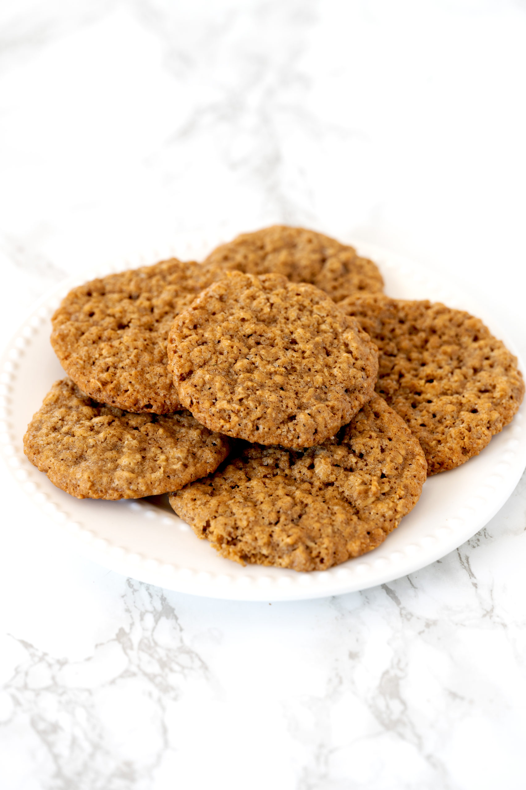 oatmeal cookies on a white plate on a white marble counter